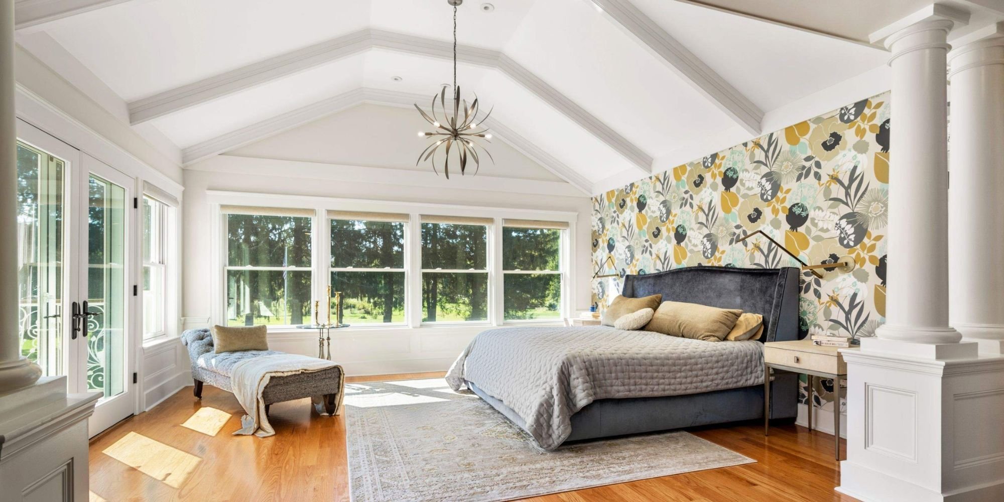 Primary bedroom addition in Grafton, MA with a vaulted ceiling, French doors opening onto a patio, and hardwood floors by Gilmore Building Co.