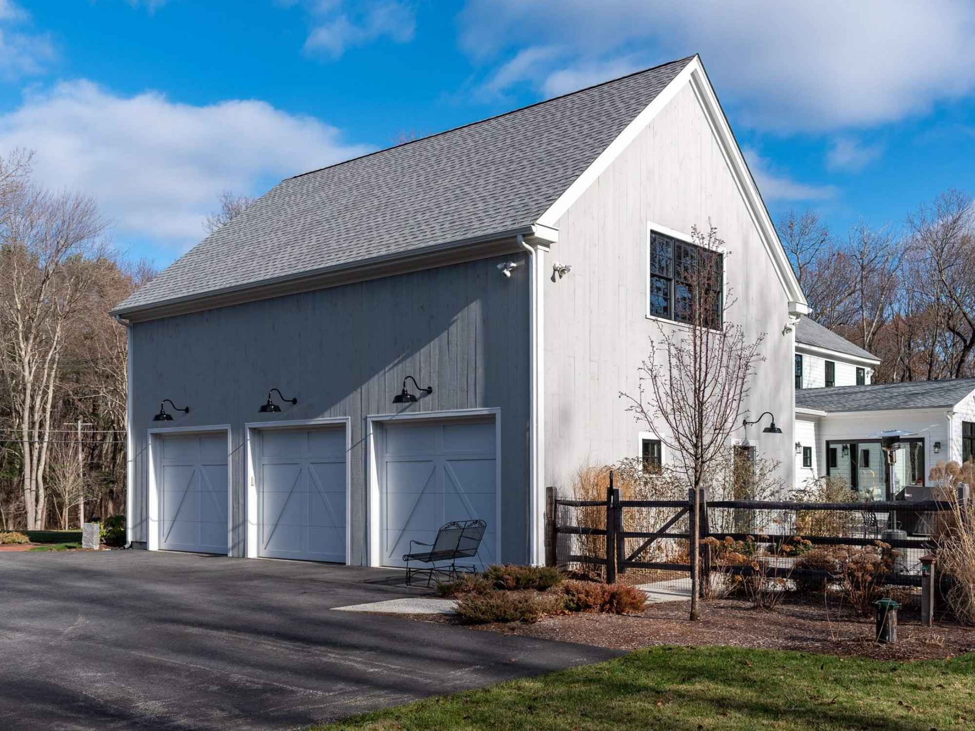 A carriage house with three garage bays in Westford, MA by Gilmore Building Co.