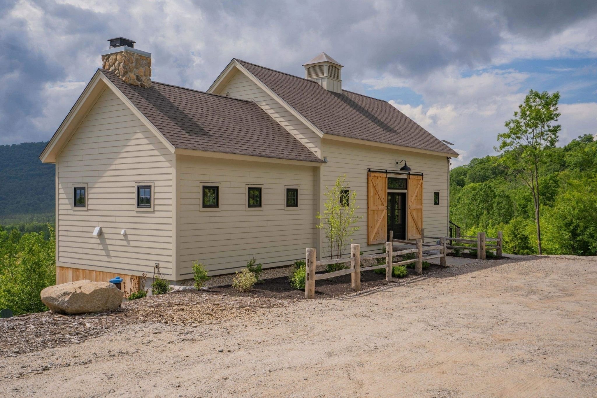 Central Massachusetts custom home exterior with square windows and barn doors by Gilmore Building Co