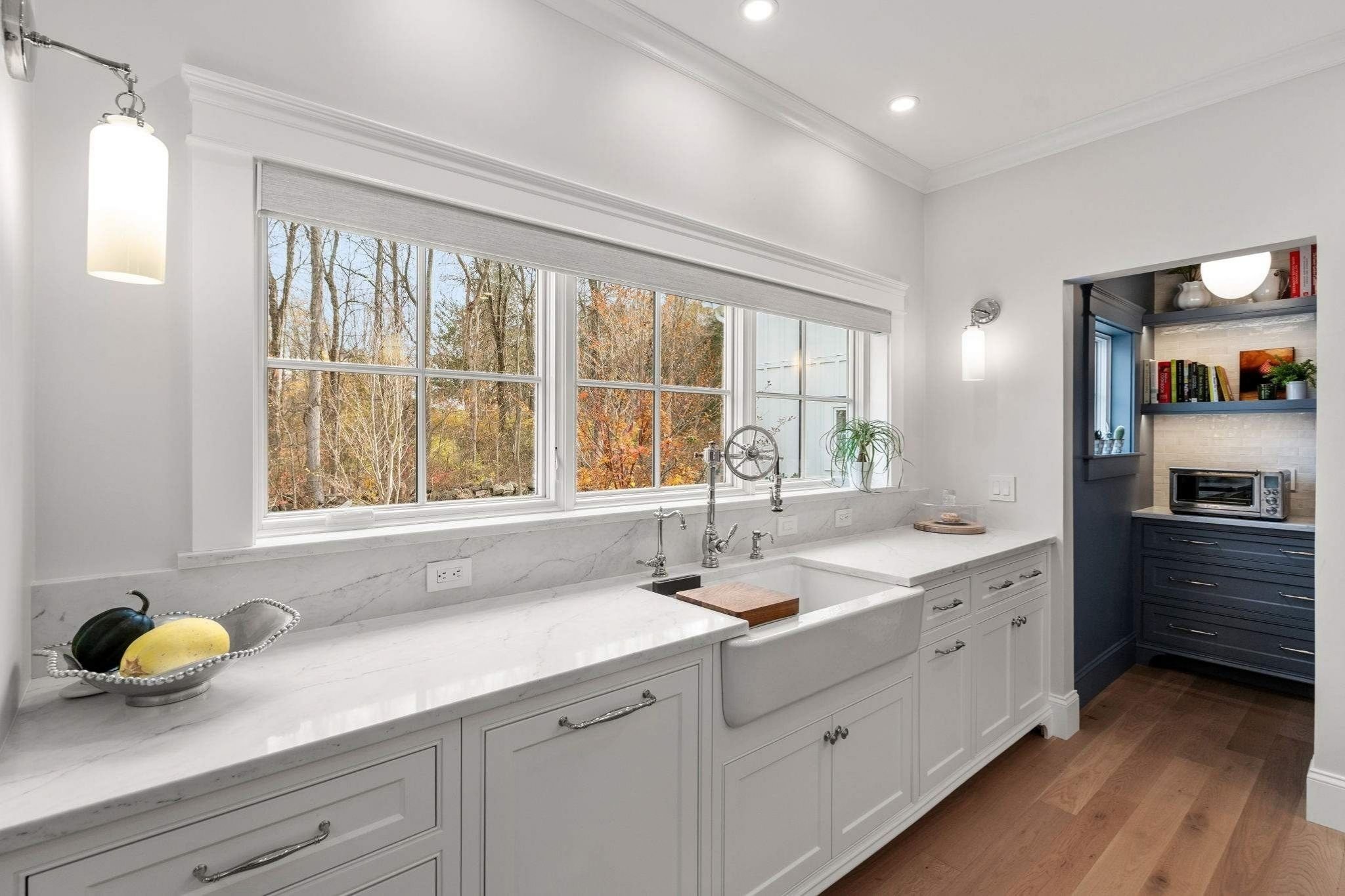 Custom kitchen in Grafton, MA with white stone countertops and custom sink hardware by Gilmore Building Co