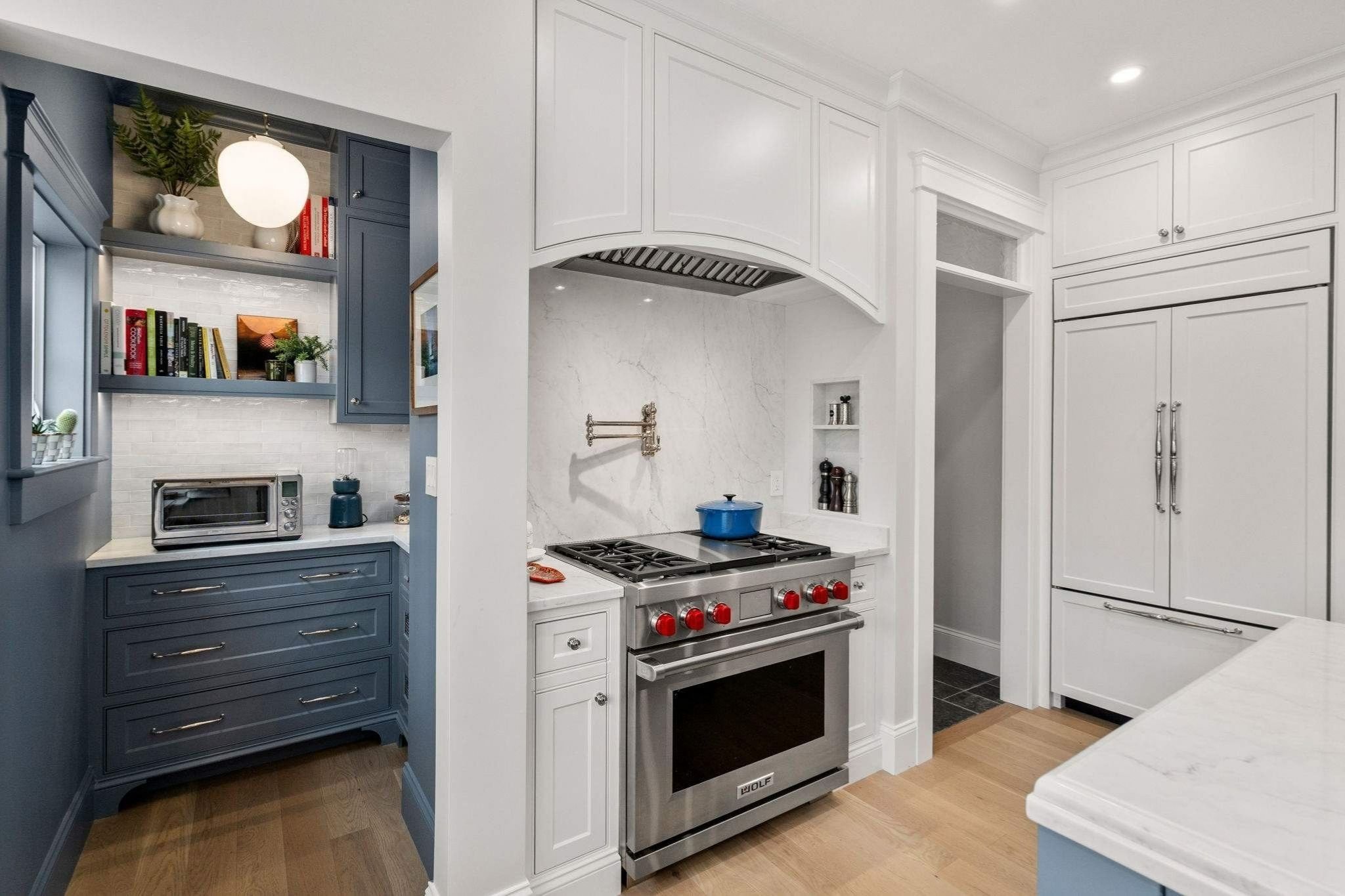 Custom kitchen in a whole home remodel in Grafton, MA with a stainless steel gas stove and pantry nook by Gilmore Building Co