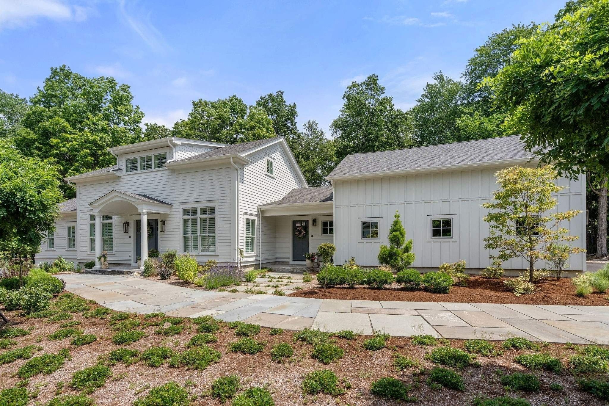Exterior of a custom home with an attached garage and stone walkway by Gilmore Building Co. in Central Massachusetts