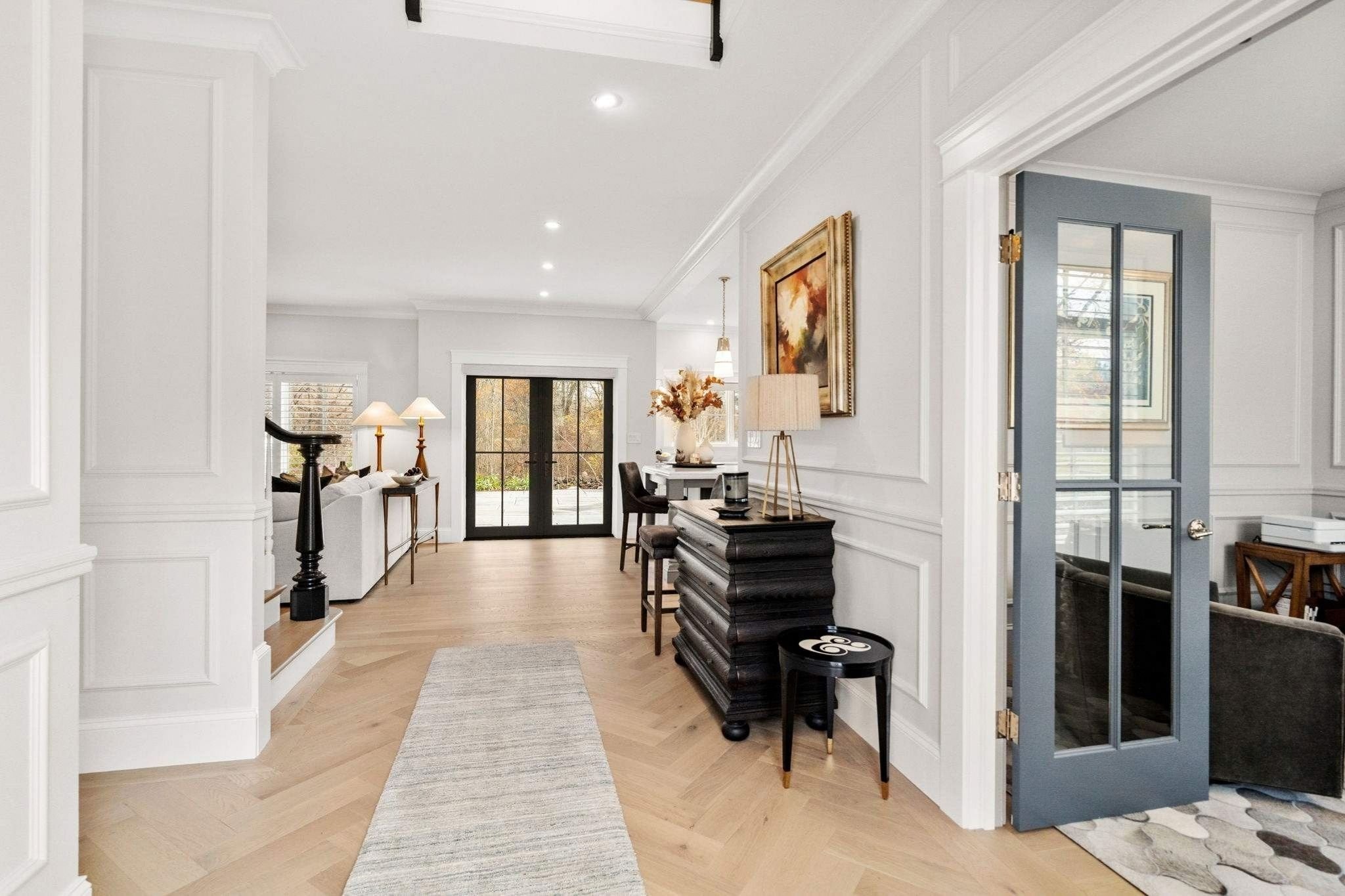 Interior of a custom home in Grafton, MA showing an open-concept kitchen and living area separated by French doors leading outsi