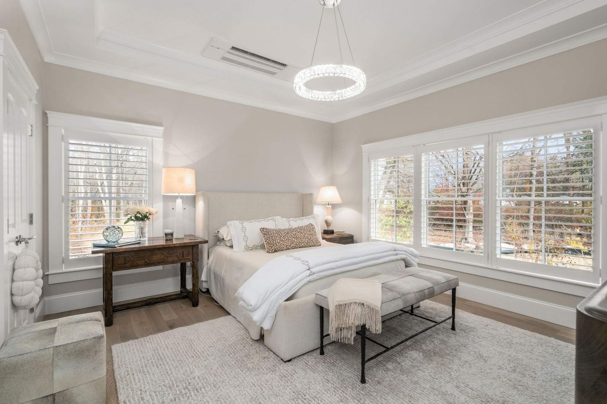 Primary bedroom in a Grafton, MA custom home with large windows, crown molding, and neutral tones by Gilmore Building Co