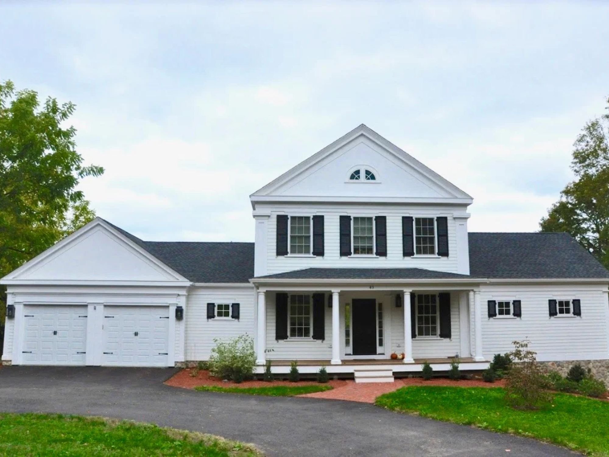 Exterior of a custom home in Boston MetroWest by Gilmore Building Co. with an attached garage and portico