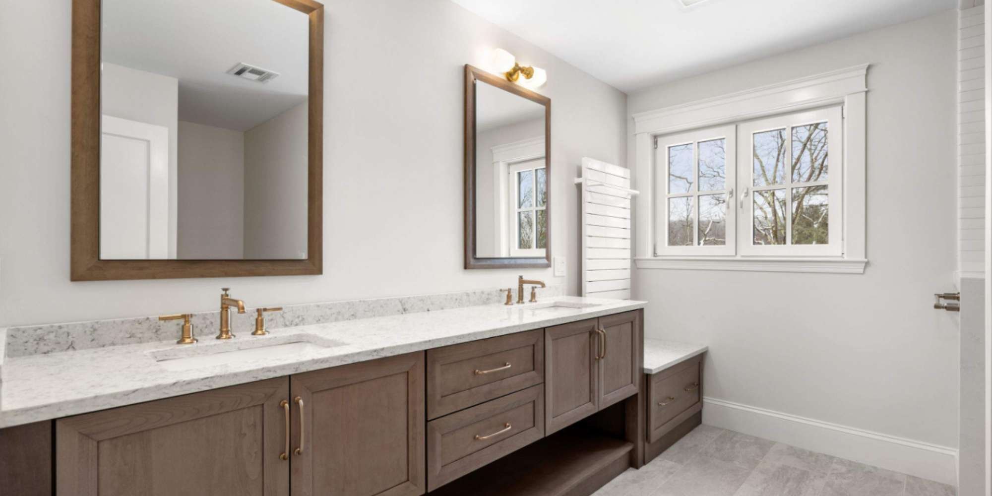 Image of a custom bathroom with a dual-sink vanity and under-cabinet storage by Gilmore Building Co
