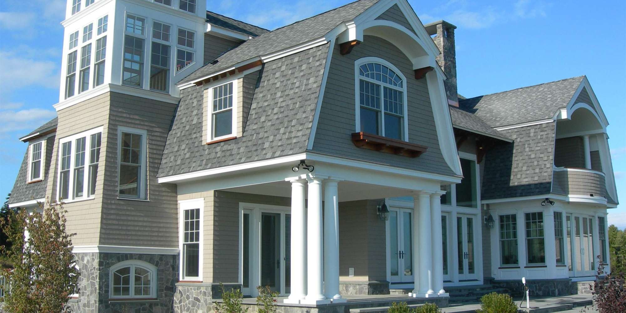 Image of a custom coastal-style home with white pillars by Gilmore Building Co in Grafton, MA