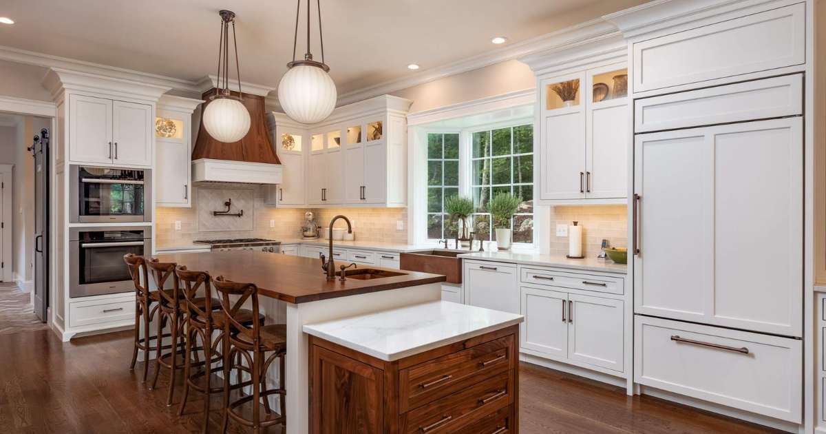 Kitchen remodel in Central MA by Gilmore Building Co. featuring white cabinets, wood island, and open-concept layout